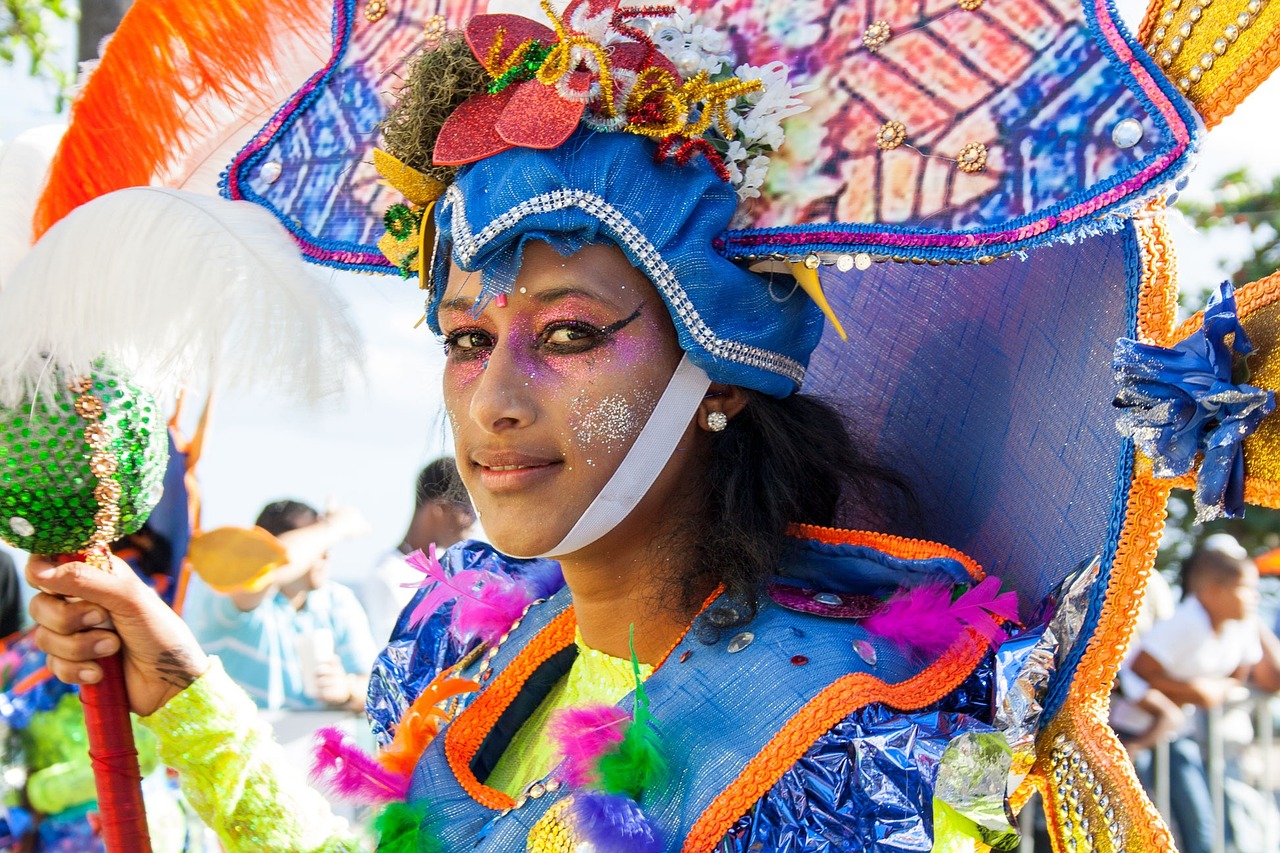 A festival performer wearing a bright blue and multicolored carnival headdress