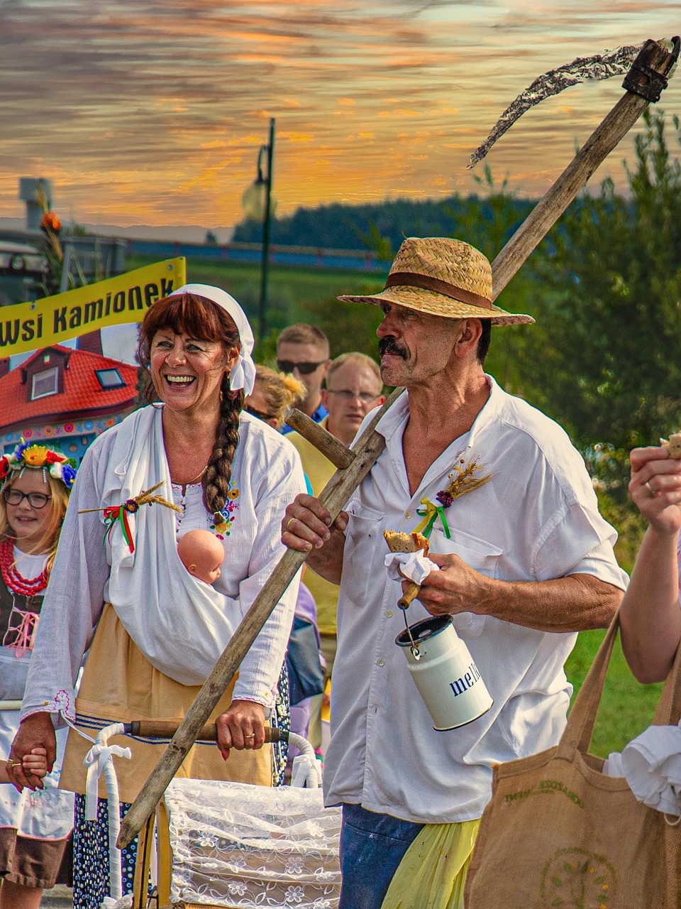 Two people in traditional clothing with musical instruments at a harvest celebration