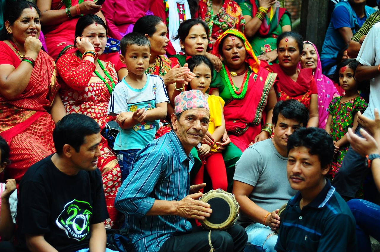 People in colorful clothing gathered around musicians at a community festival in Nepal