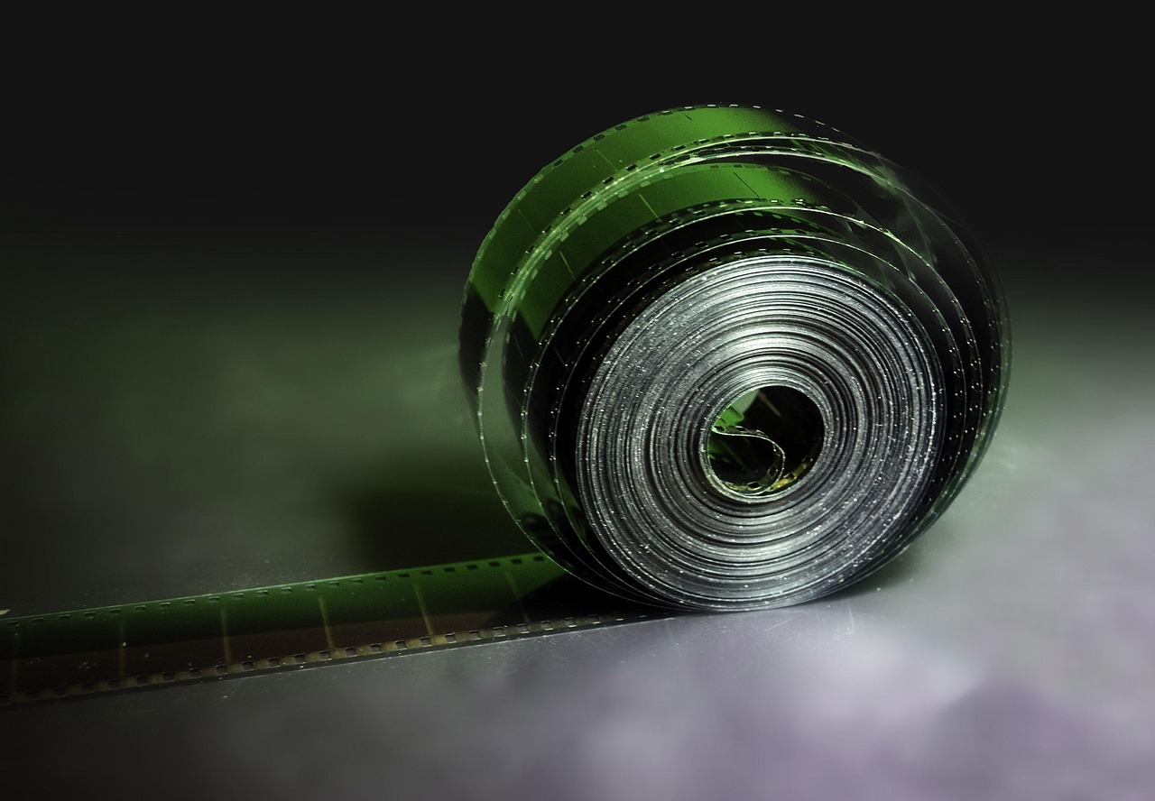 A roll of cinema film on a dark studio surface
