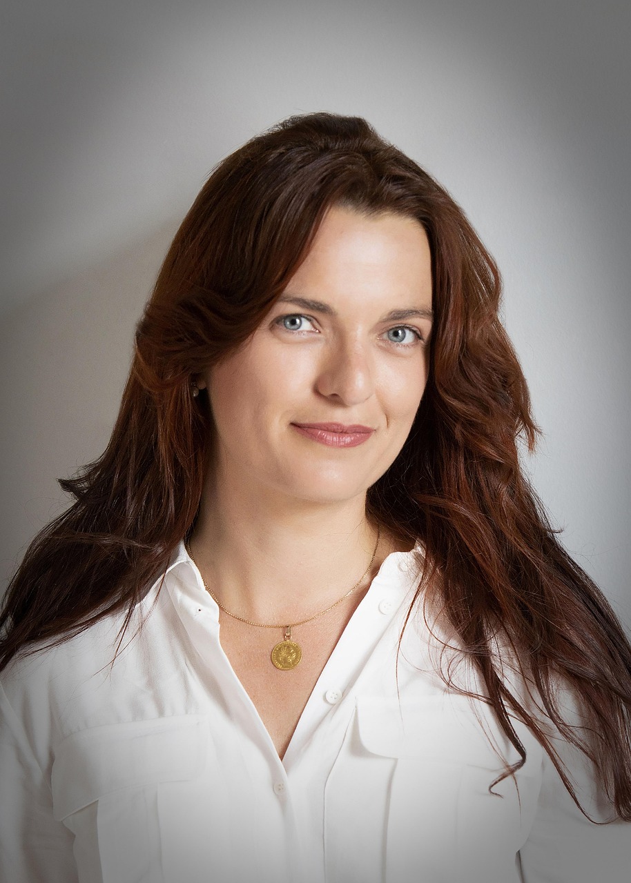 A woman in a white shirt photographed in a softly lit professional headshot