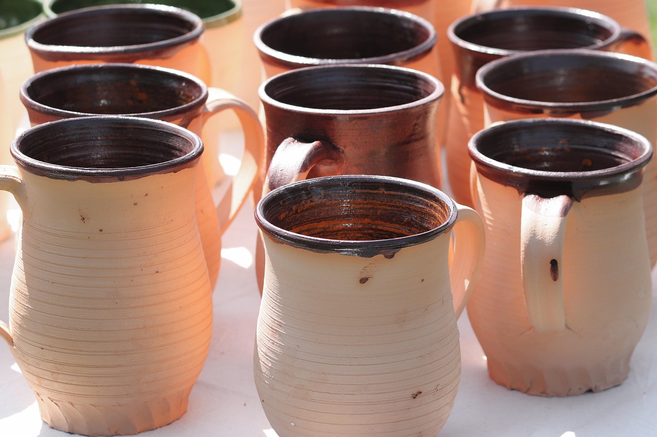 Rows of handmade cream and brown ceramic mugs photographed together
