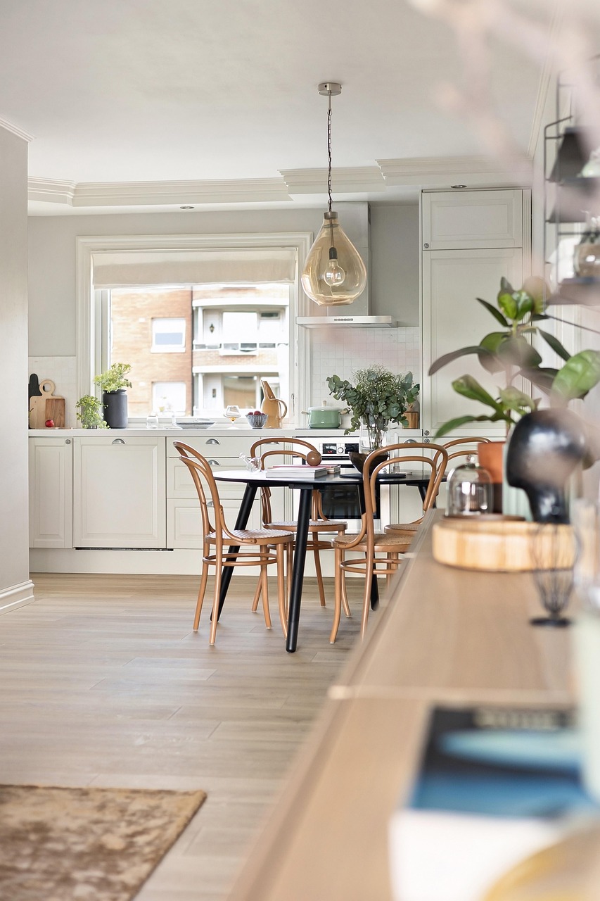 A bright white kitchen and dining area viewed from an adjoining room