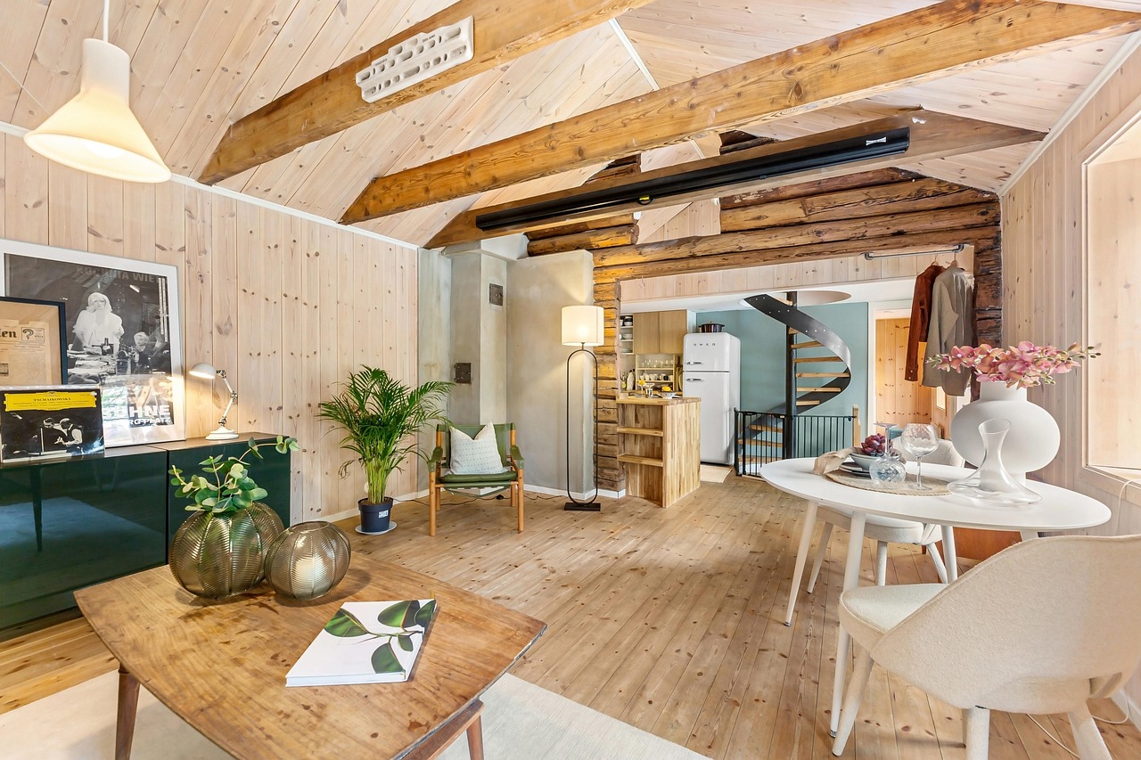 An open-plan interior with timber beams, a kitchen island and a dining area