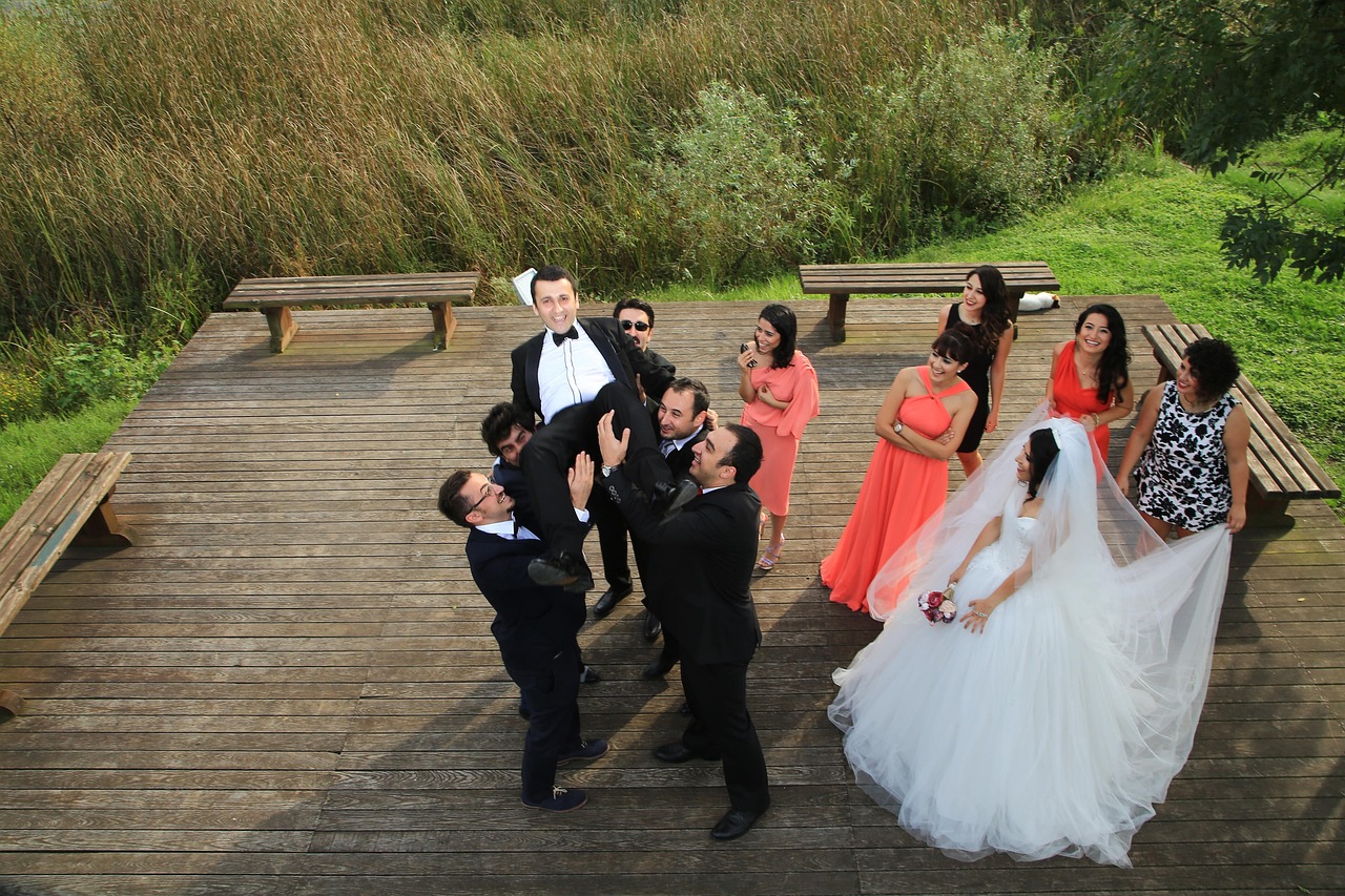 A bride and groom celebrating with their wedding party on a wooden deck